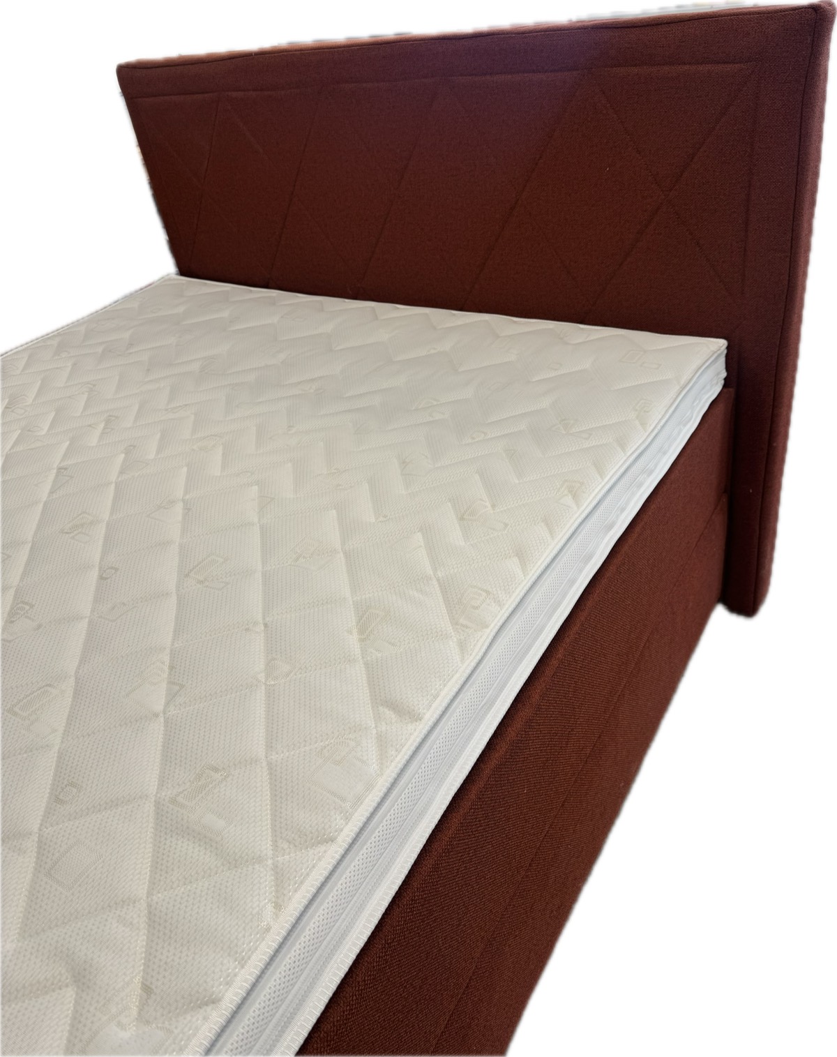 Topper with a 100% polyester knit cover, on the bed