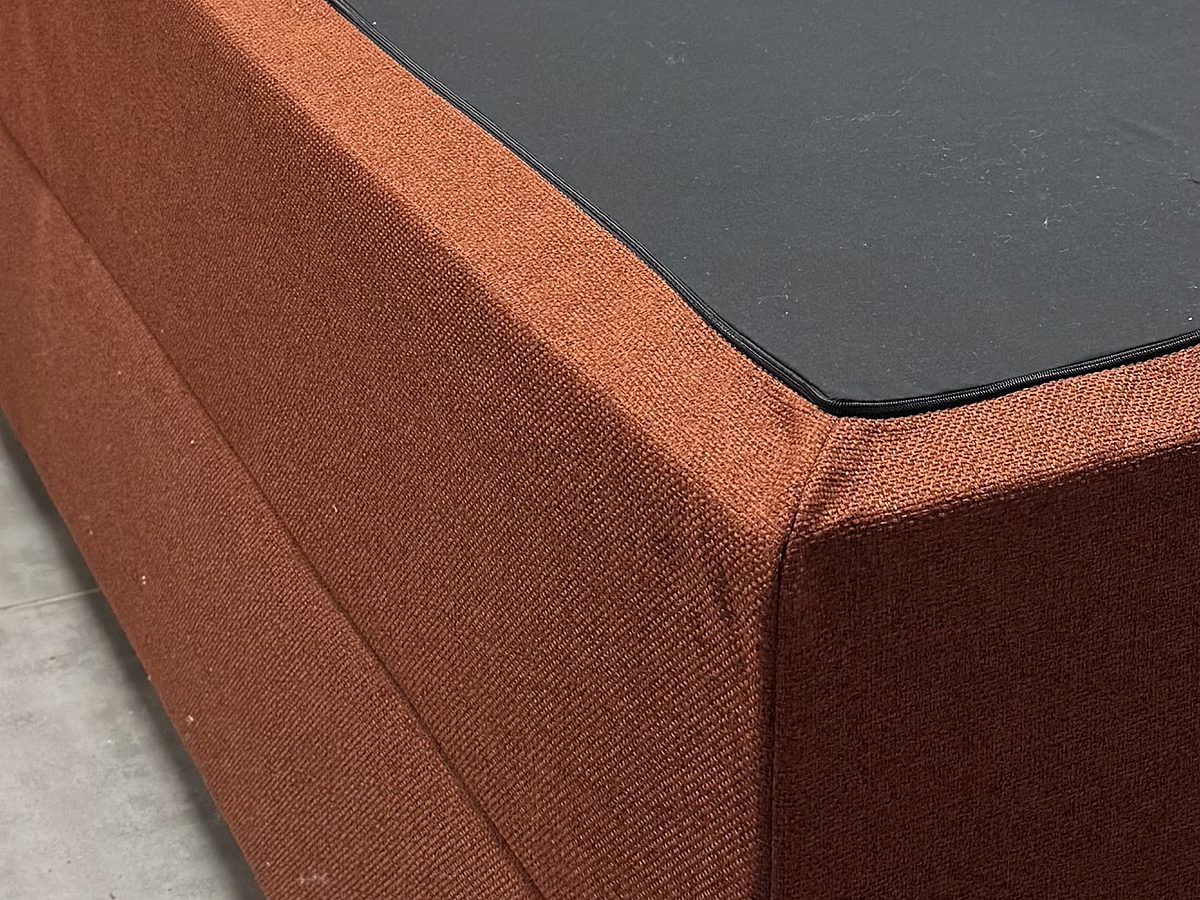 The storage box with the lid panel in a black cover with piping